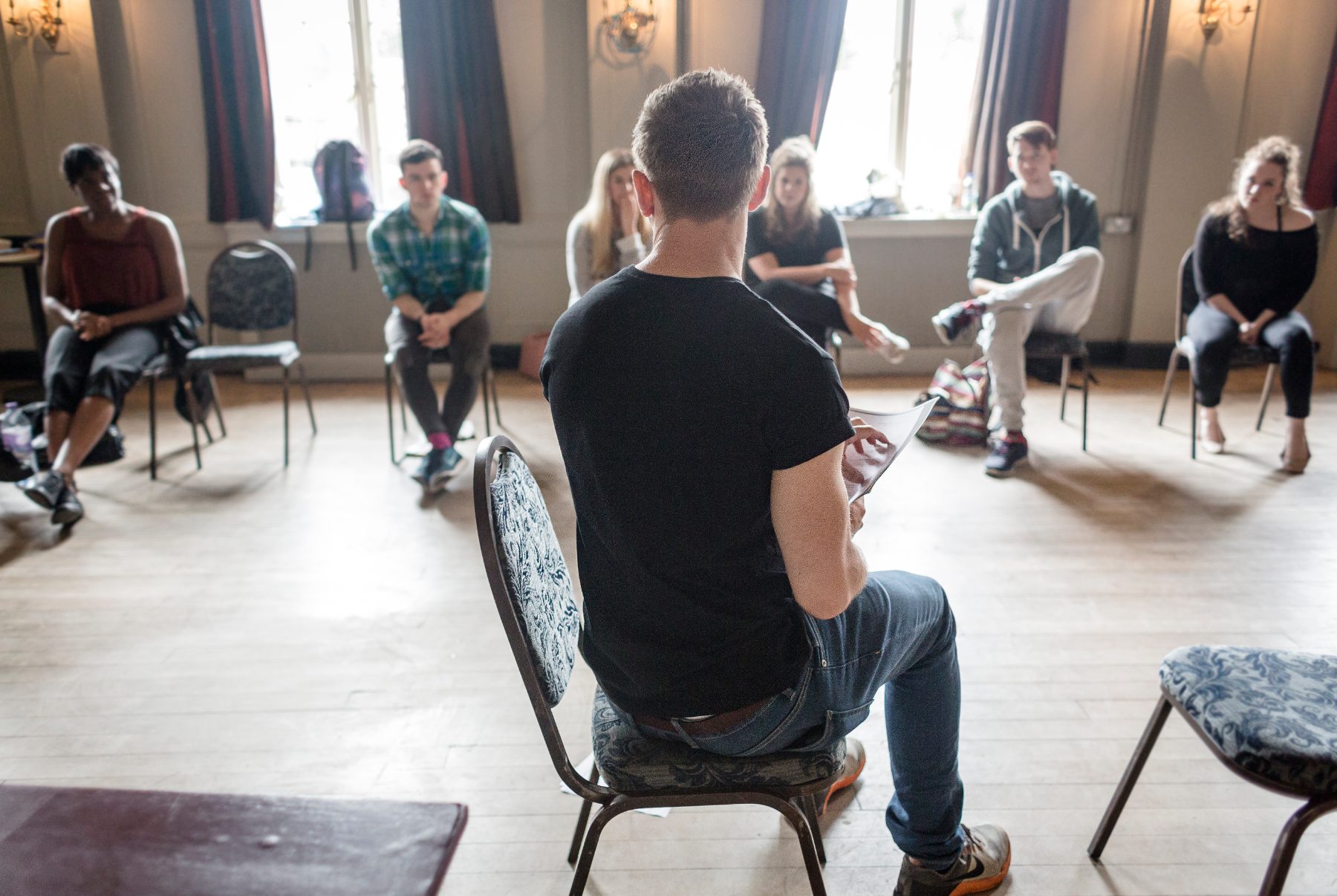 Adam leading a session with actors seated in a circle