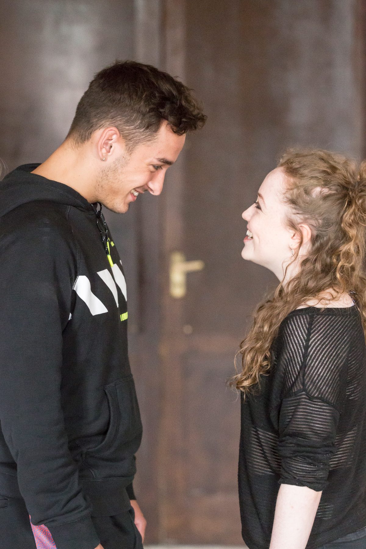 Two actors facing each other, smiling